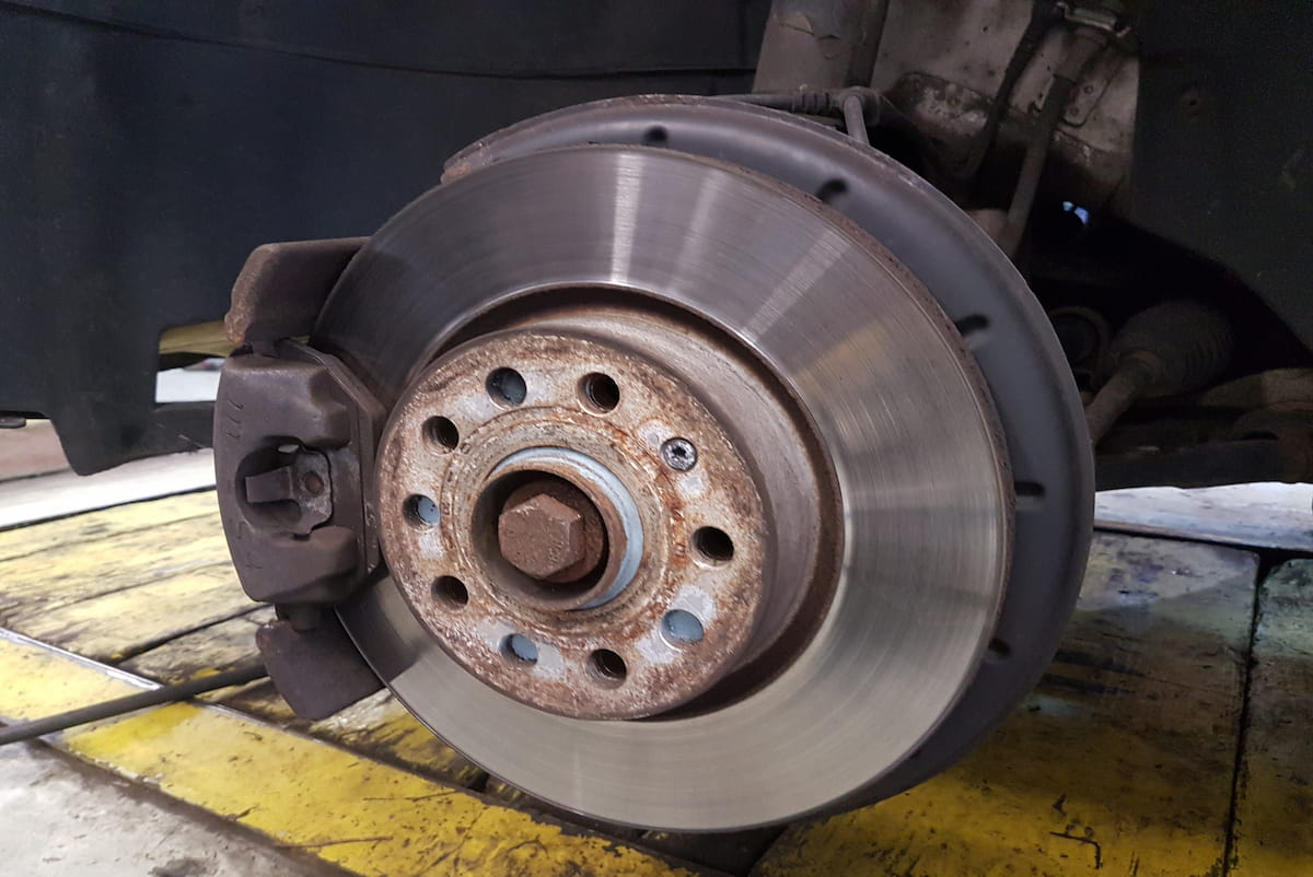 Wheel removed for brake pad and rotor replacement during a mobile brake job in Jacksonville, NC